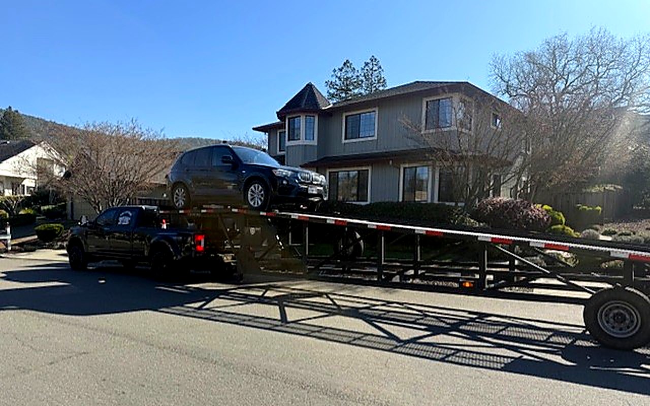 Car hauler loaded with a vehicle parked on a residential street