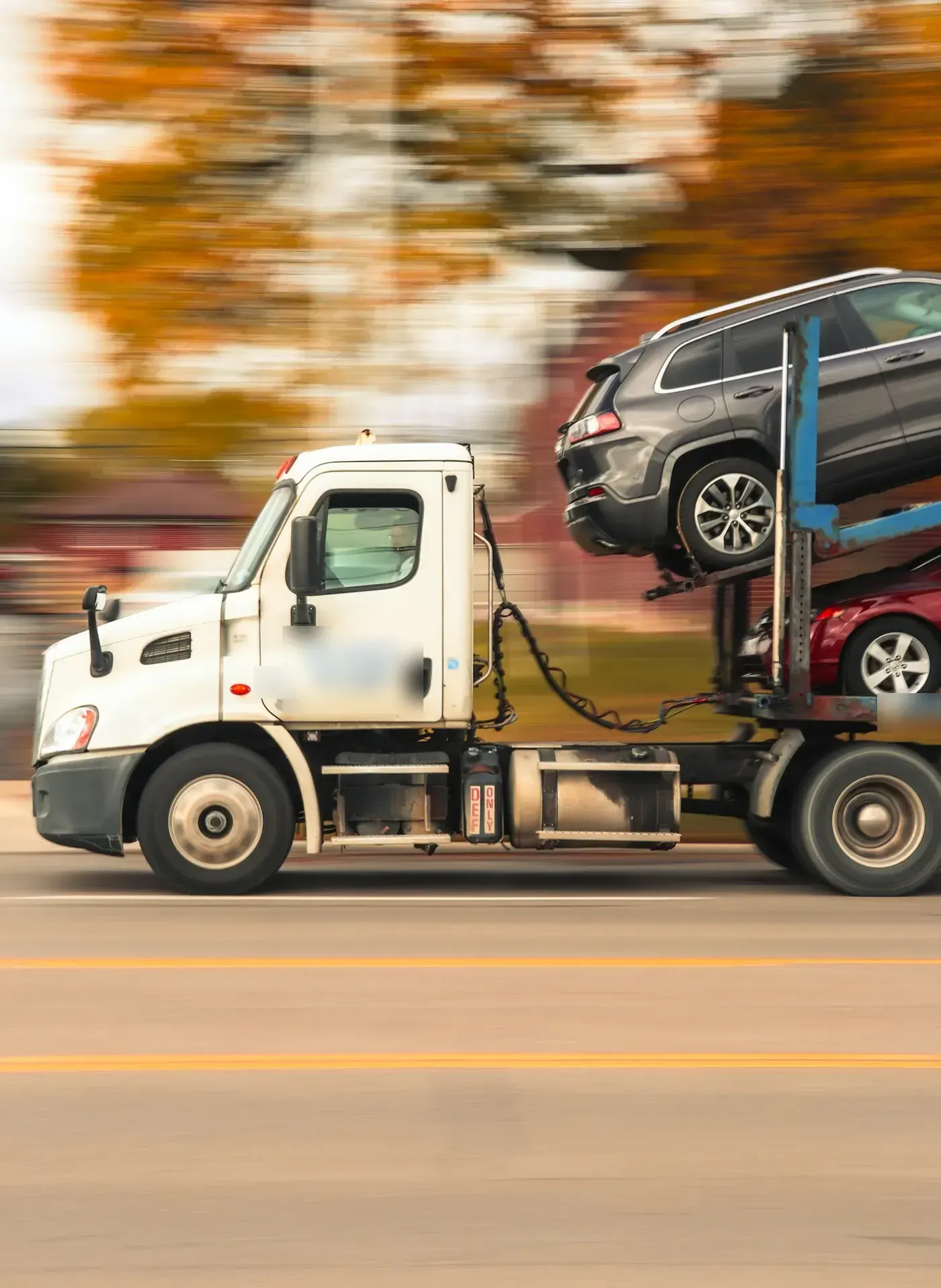 US car hauler with USDOT and MC numbers on the door, loaded with vehicles